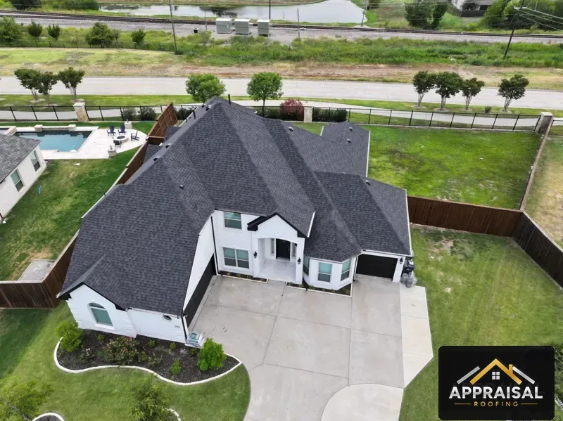 New dark shingle roof on a white stone home
