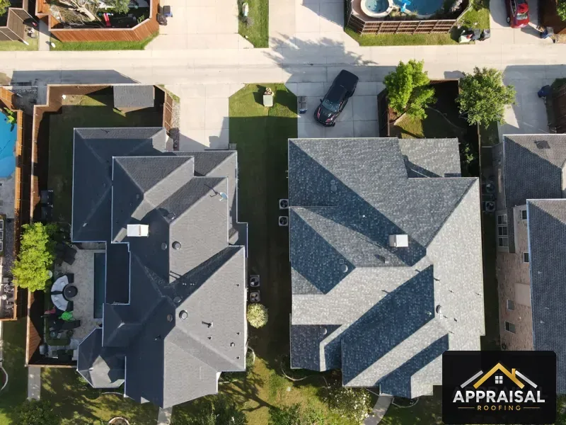 Two neighboring homes with new roofs, drone view